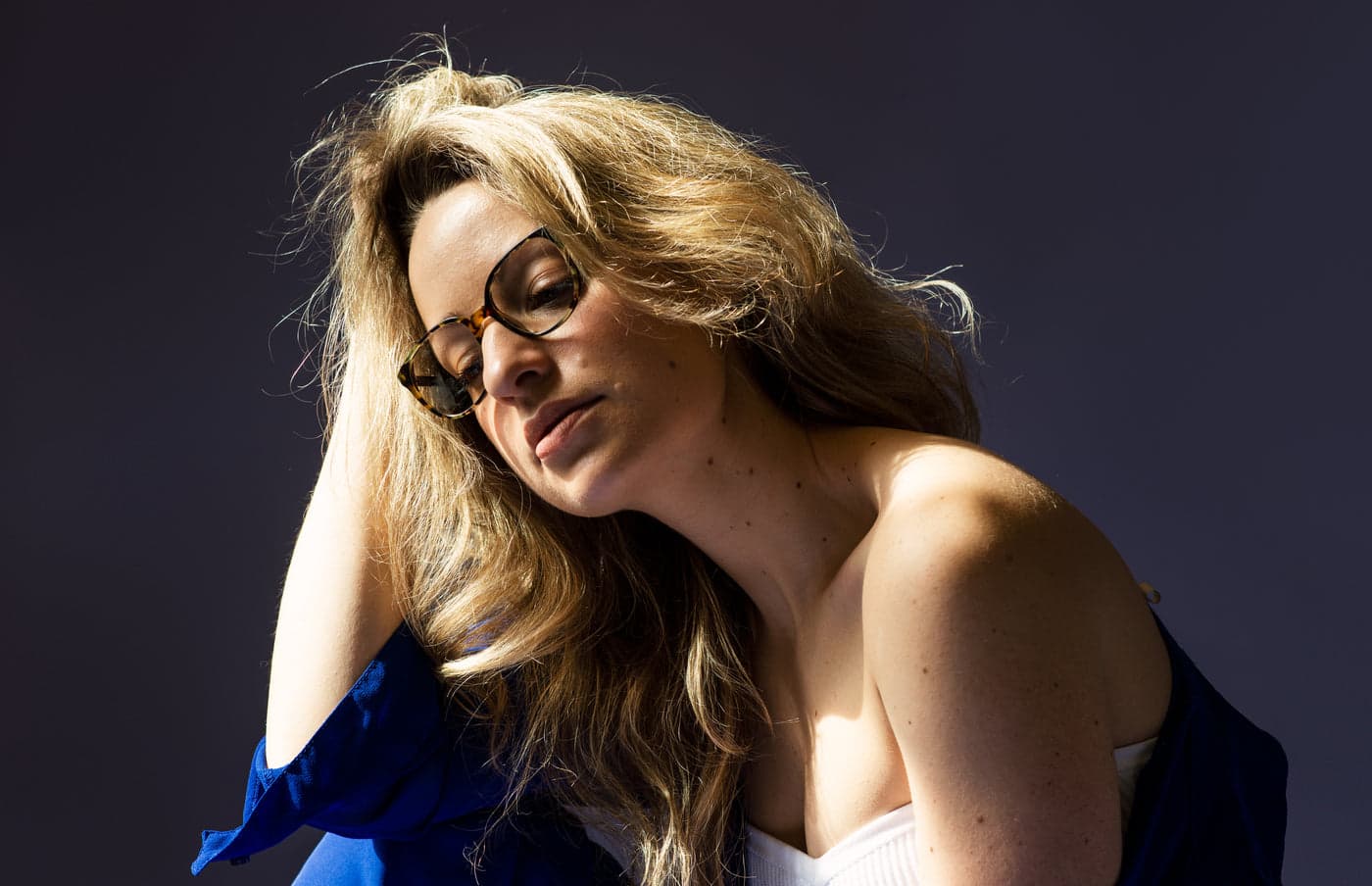 A woman wearing thin metal glasses