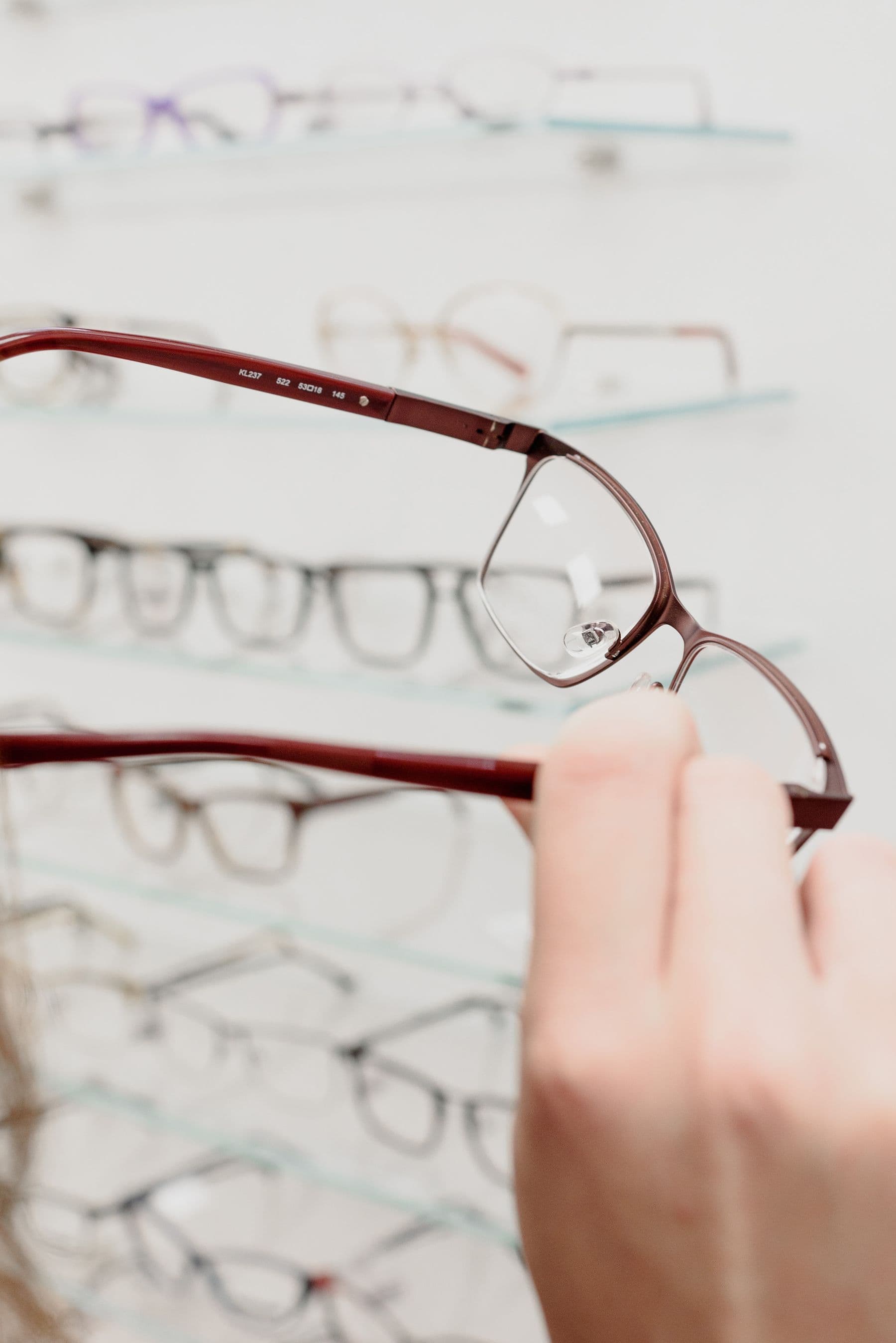 A woman trying on glasses in an optical shop